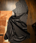 Black Leather draped over a wooden surface