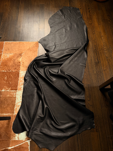 Black Leather draped over a wooden surface