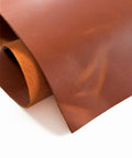 Folded tan Crazy Horse cowhide sheet showing thickness, pull-up finish, and suede back
